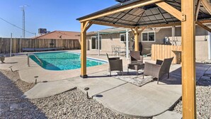 A backyard with a swimming pool, covered patio area, and outdoor furniture. - 5 Mi to Marina: Lake Havasu City Home w/ Pool! (Lake Havasu City)