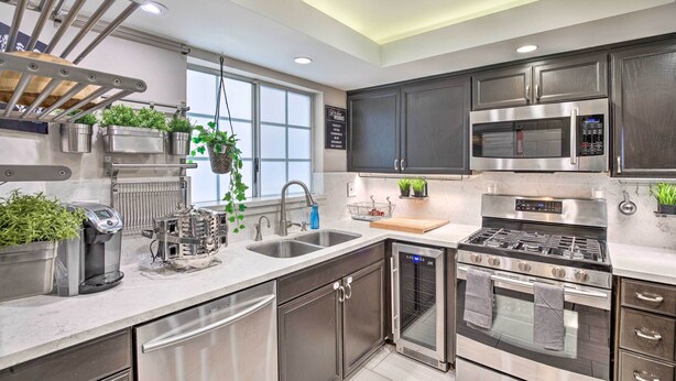 A modern kitchen with stainless steel appliances, a built-in oven, and a dishwasher.