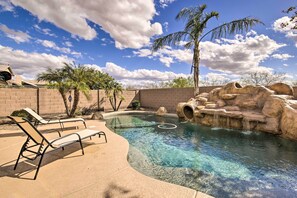 A clear swimming pool with lounge chairs, palm trees, and a rocky landscape. - Game Room & Pool w/ Slide: Mesa Oasis! (Mesa)