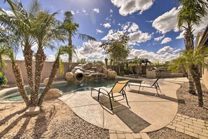 A pool area with palm trees, lounge chairs, and a rocky water feature. - Game Room & Pool w/ Slide: Mesa Oasis! (Mesa)