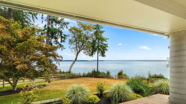 A deck with a view of a lake, surrounded by trees and plants. - Hike, Bike & Explore: Oceanfront Kingston Getaway (Kingston)