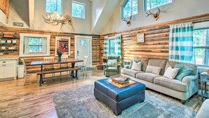 A spacious log cabin interior with a dining area, a sofa, and a chandelier. - 1 Mi to Lake: Chic Arizona Cabin w/ Large Porch! (Lakeside)