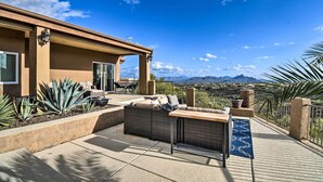 Un patio con mobiliario exterior, una pérgola y vistas a las montañas.