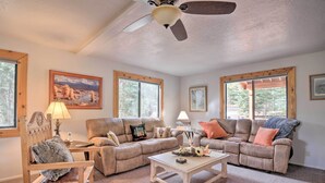 A spacious living room with two couches, a coffee table, and a ceiling fan. - Duck Creek Village Cabin w/ Deck on Half Acre (Duck Creek Village)