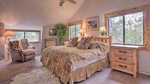 A bedroom with a large bed, a chair, a desk, and a ceiling fan. - Duck Creek Village Cabin w/ Deck on Half Acre (Duck Creek Village)