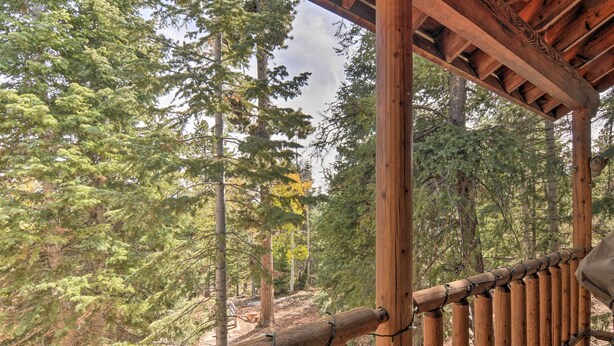 A wooden deck with a railing overlooking a forested area. - Duck Creek Village Cabin w/ Deck on Half Acre (Duck Creek Village)