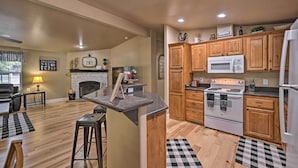 A spacious kitchen with wooden cabinets, a microwave, and a stove. - Near Hiking: Munds Park Cabin w/ Deck & Yard (Munds Park)