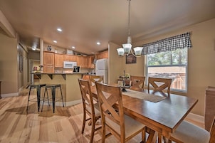 Una cocina amplia con armarios de madera, una isla central y un comedor con mesa y sillas de madera.