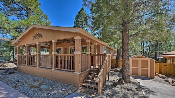 A wooden cabin with a porch, a garage, and a well-maintained gravel driveway. - Near Hiking: Munds Park Cabin w/ Deck & Yard (Munds Park)