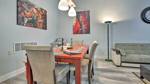 A dining area with a wooden table, chairs, and artwork on the walls.