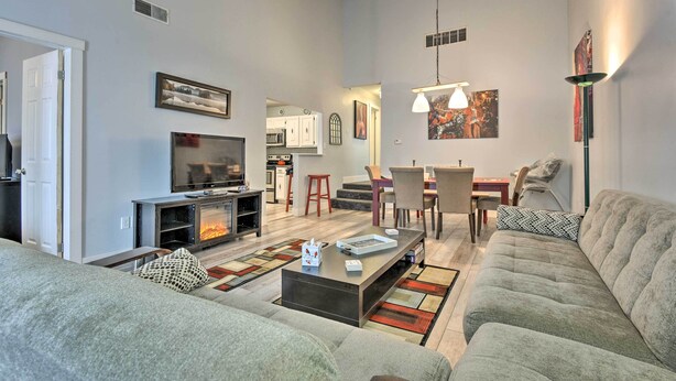 A modern living room with a fireplace, sofa, coffee table, and artwork.