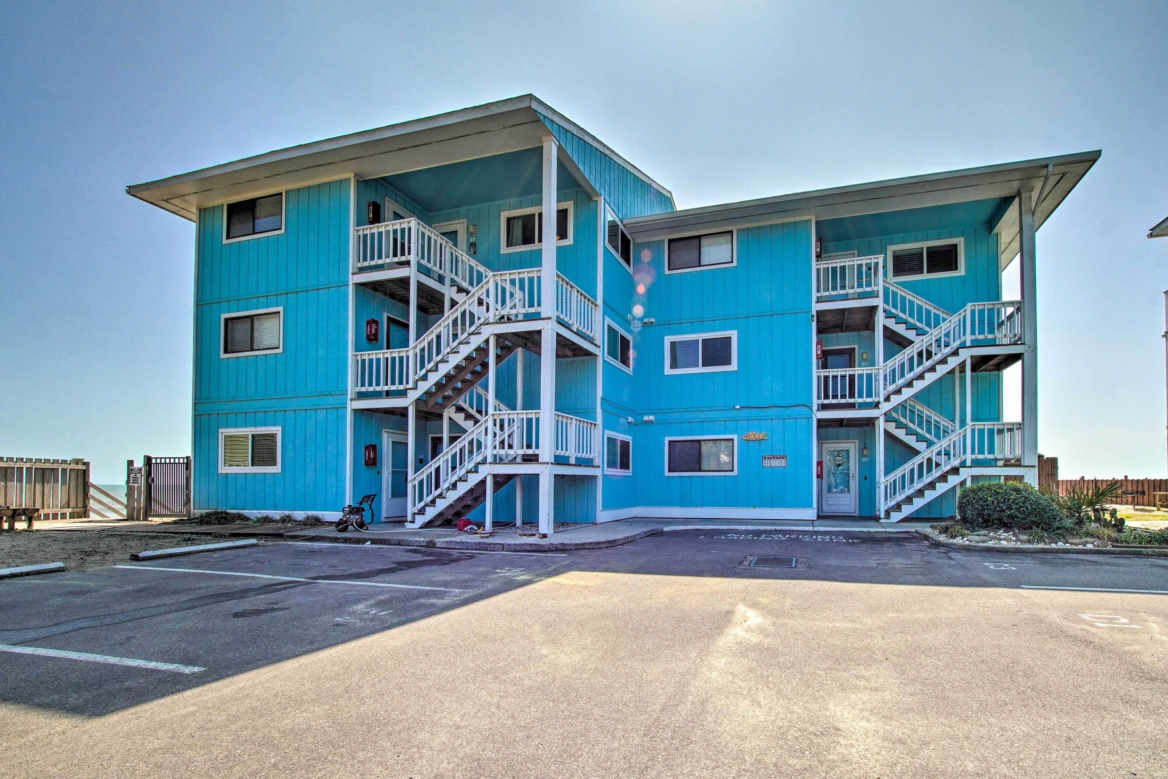 A multi-story blue building with balconies and a central staircase.