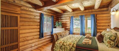 Una habitación estilo cabaña de troncos con una cama de madera, un aparador y una ventana con cortinas.