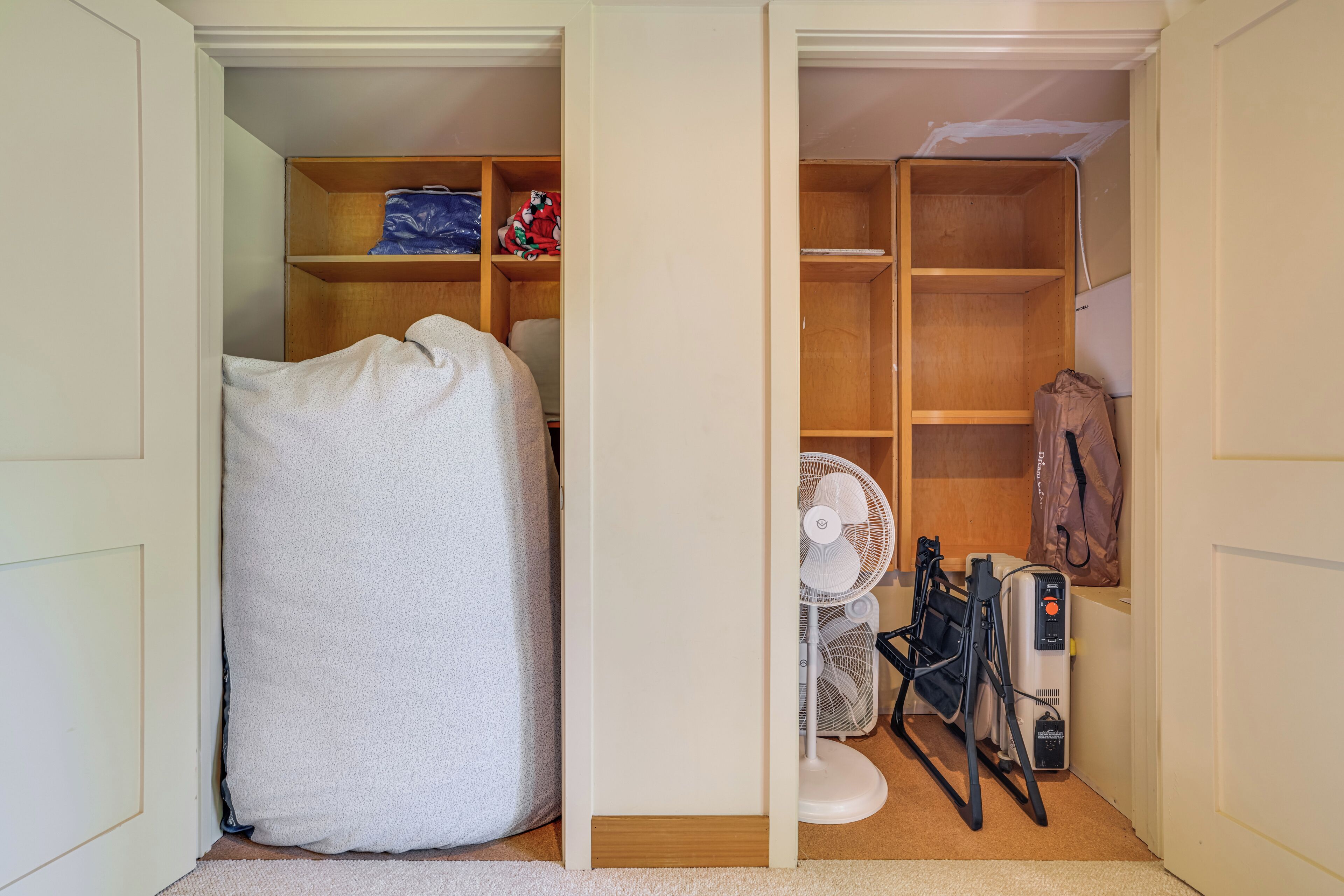 Une pièce comprenant un lit, un ventilateur, un radiateur et une étagère avec divers objets.