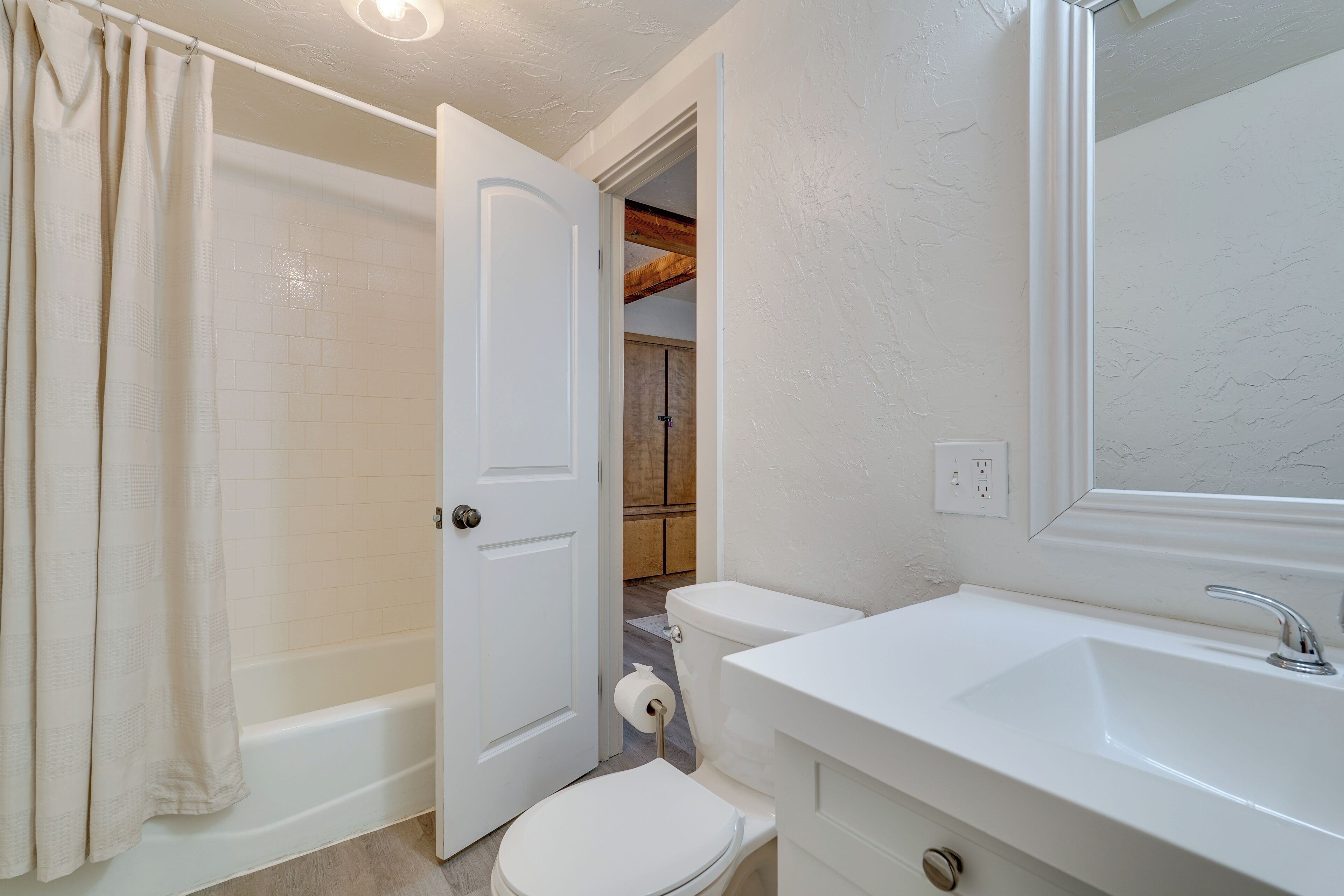 A bathroom with a bathtub, toilet, and sink.