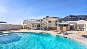 A residential pool area with a two-story house, a covered patio, and outdoor furniture. - Pool, Game Room, Hot Tub: Lake Havasu City Oasis! (Lake Havasu City)