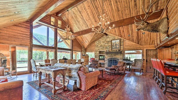 A spacious lodge with a high wooden ceiling, a large dining area, and a fireplace. - Fish Creek Ranch Lodge With Hot Tub and Game Room (Dolores)