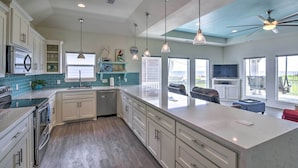 A spacious kitchen with a large island, built-in appliances, and pendant lighting. - Walk to Ocean: Bright Crystal Beach House w/ Deck! (Port Bolivar)