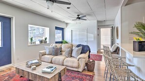 Una sala de estar moderna con un sofá color beige, una mesa de centro y un tapete rojo estampado.