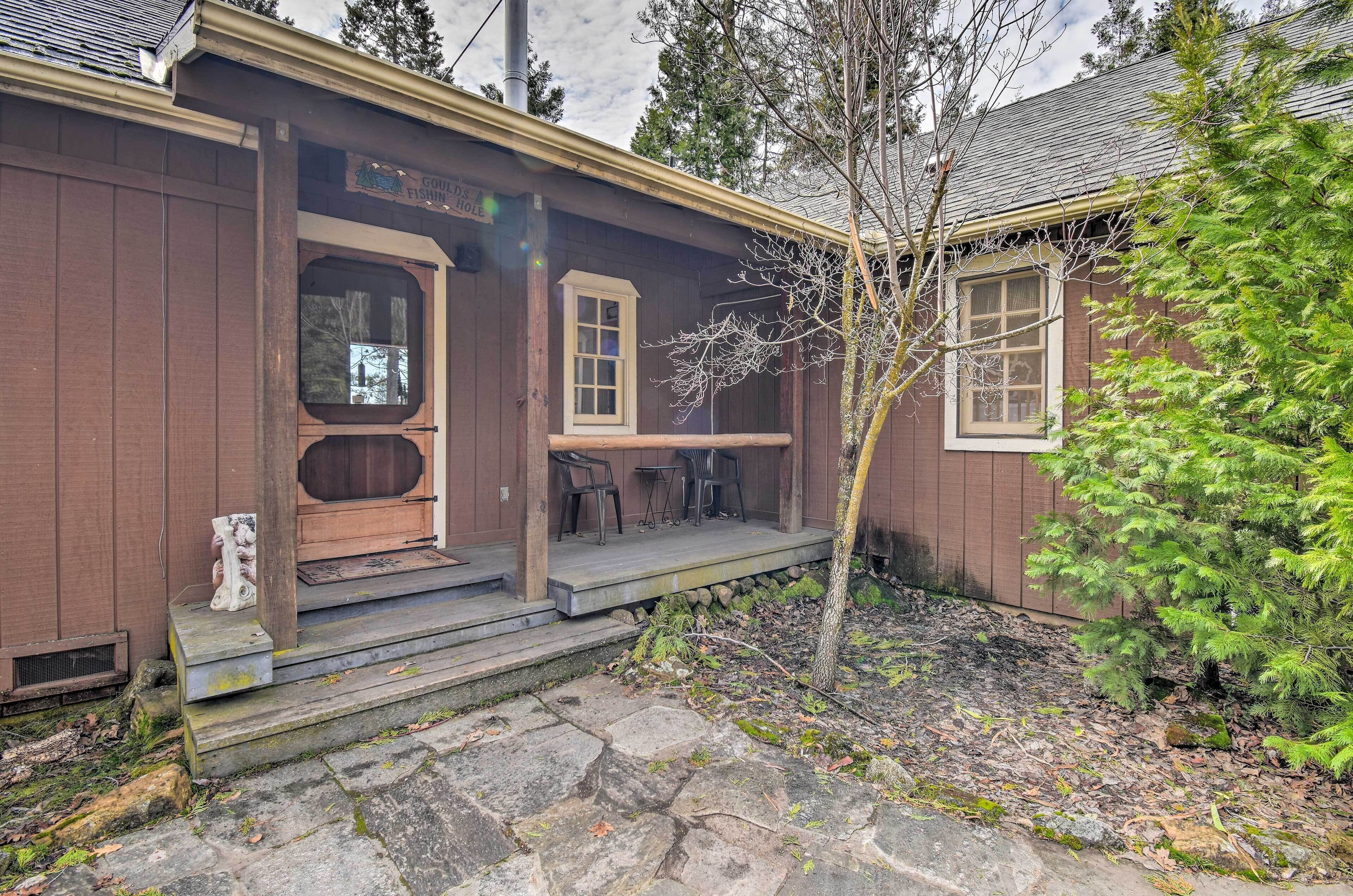 A wooden building with a porch, a door, and a window.