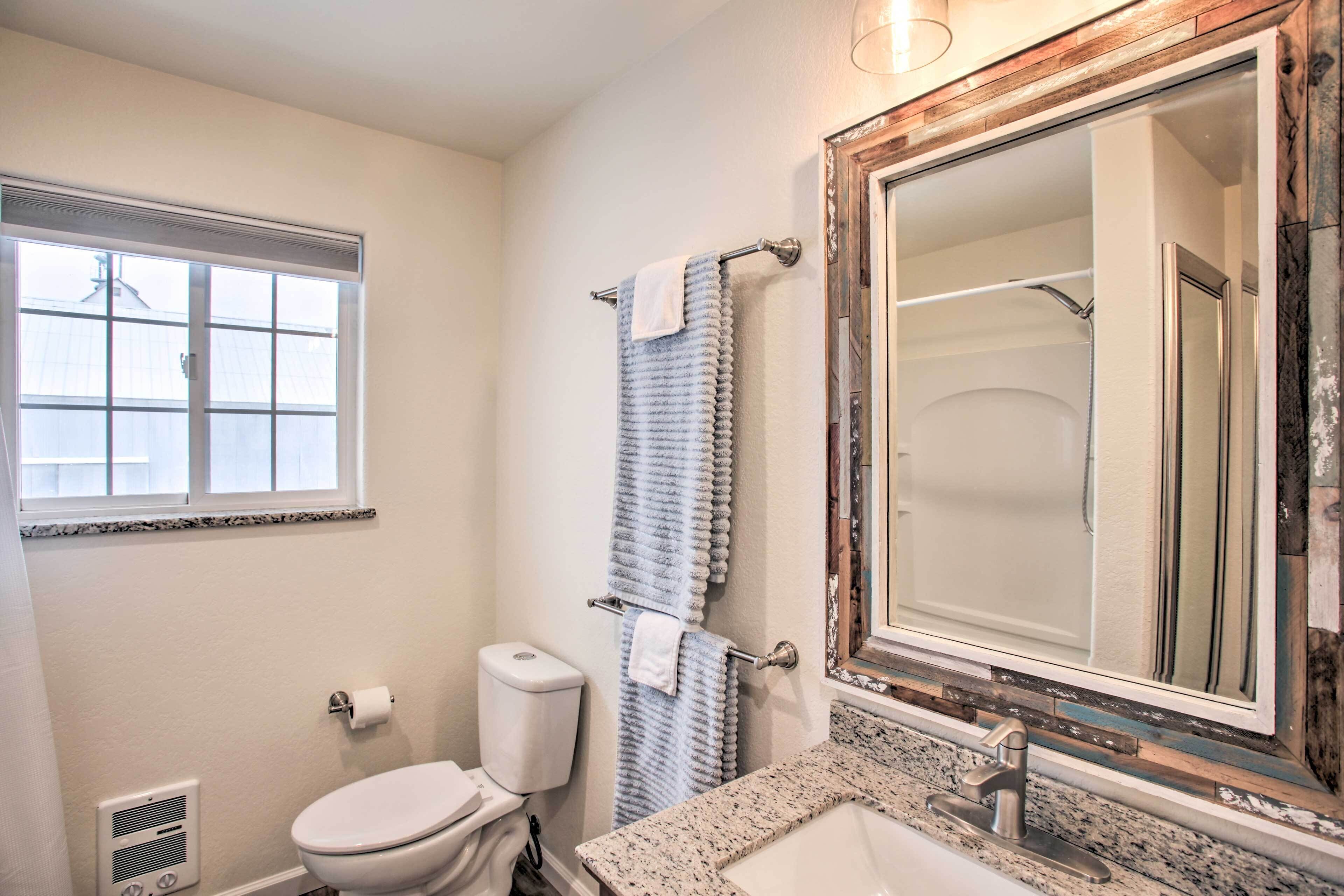 A bathroom with a toilet, sink, and large mirror.