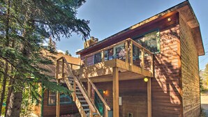 Eine Holzhütte mit einer Holztreppe, die zu einem Balkon führt.