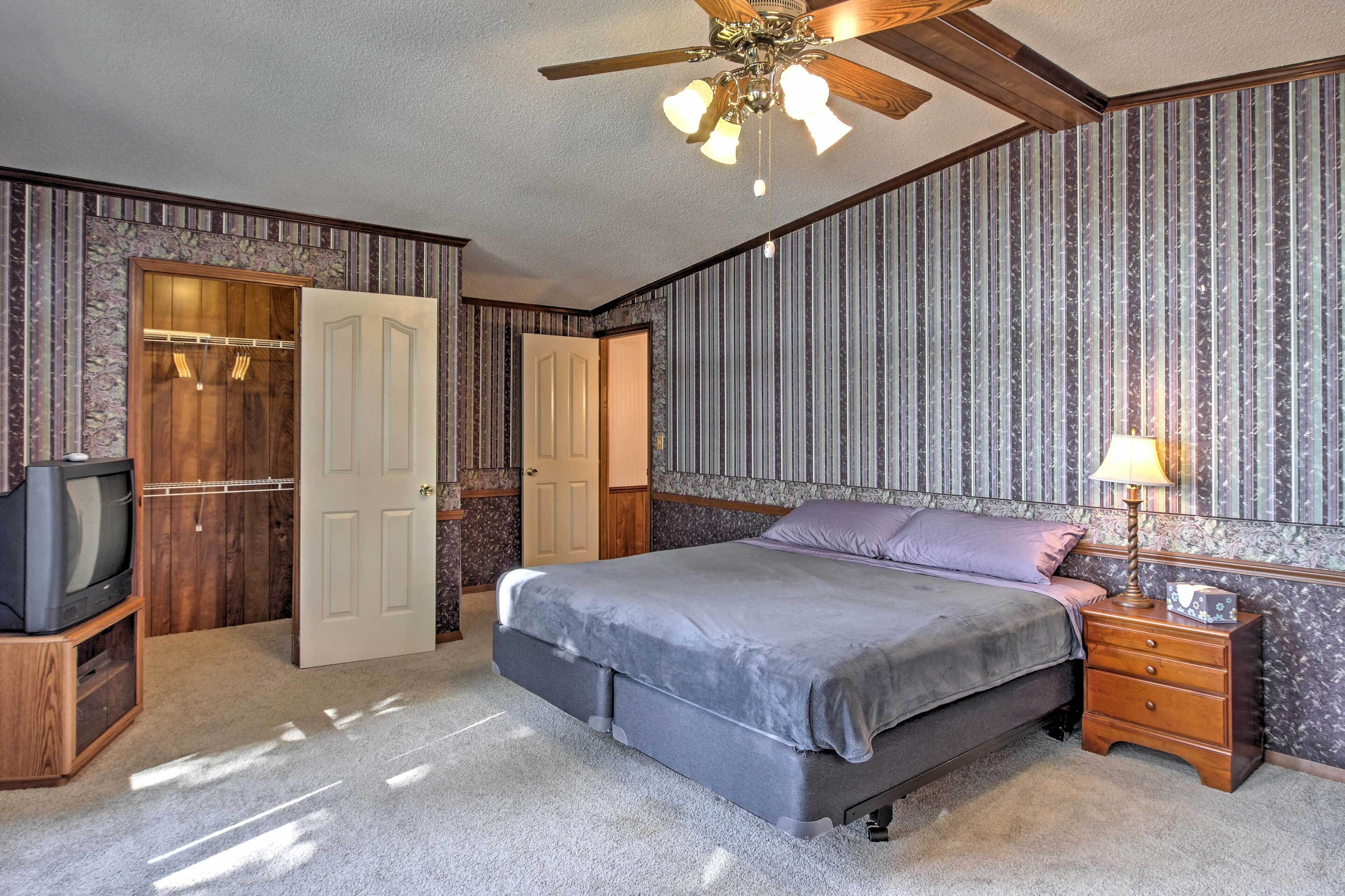 Une chambre à coucher comprenant un lit, une table de chevet, un téléviseur et une armoire.