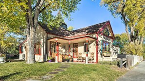 A house with a sloped roof, a front porch with chairs, and a mailbox. - Victorian Gem! Steps to Dine, Shop & Hike (Carbondale)