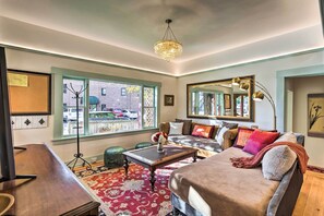 A cozy living room with a sofa, coffee table, and a chandelier.