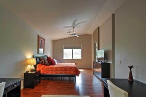 A bedroom with a bed, a desk, a chair, a dresser, a TV, and a ceiling fan. - Zen Phoenix Home on Legacy Golf Course w/ Pool! (Phoenix)