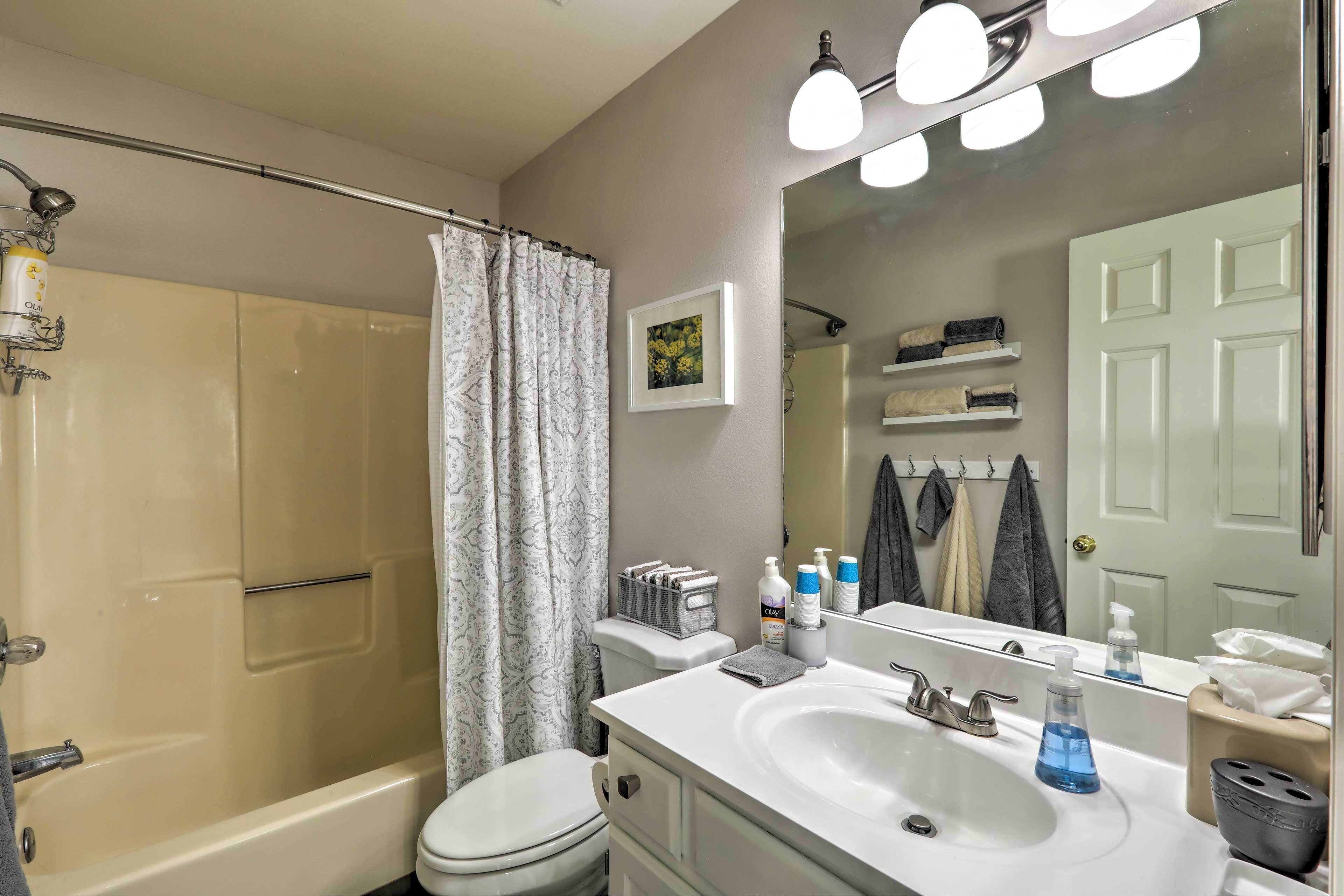 A bathroom with a bathtub, toilet, sink, and a shower curtain.