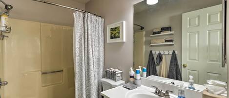 A bathroom with a bathtub, toilet, sink, and a shower curtain.