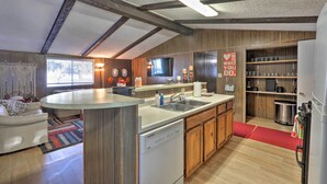 Une cuisine moderne dotée d’un îlot central, de meubles en bois et d’un lave-vaisselle encastré.