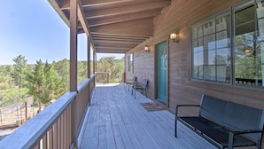 A wooden deck with a bench and chairs, a door with a green frame, and a view of trees. - Modern Show Low Retreat w/ Deck & Mtn Views! (Show Low)