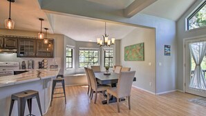 A spacious kitchen with a large island, wooden flooring, and pendant lighting. - Modern Show Low Retreat w/ Deck & Mtn Views! (Show Low)