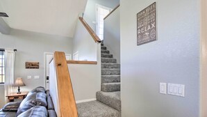 A staircase with a wooden handrail leading to a door. A sign on the wall lists cabin rules. - Modern Show Low Retreat w/ Deck & Mtn Views! (Show Low)