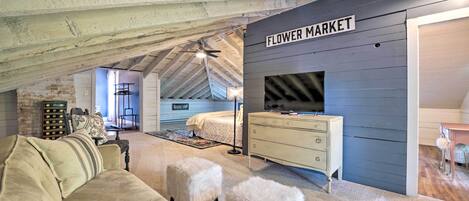 An attic bedroom with a loft bed, a dresser, and a sign reading "Flower Market".