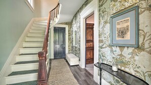 Un escalier avec une rampe en bois, un banc et un tableau encadré au mur.