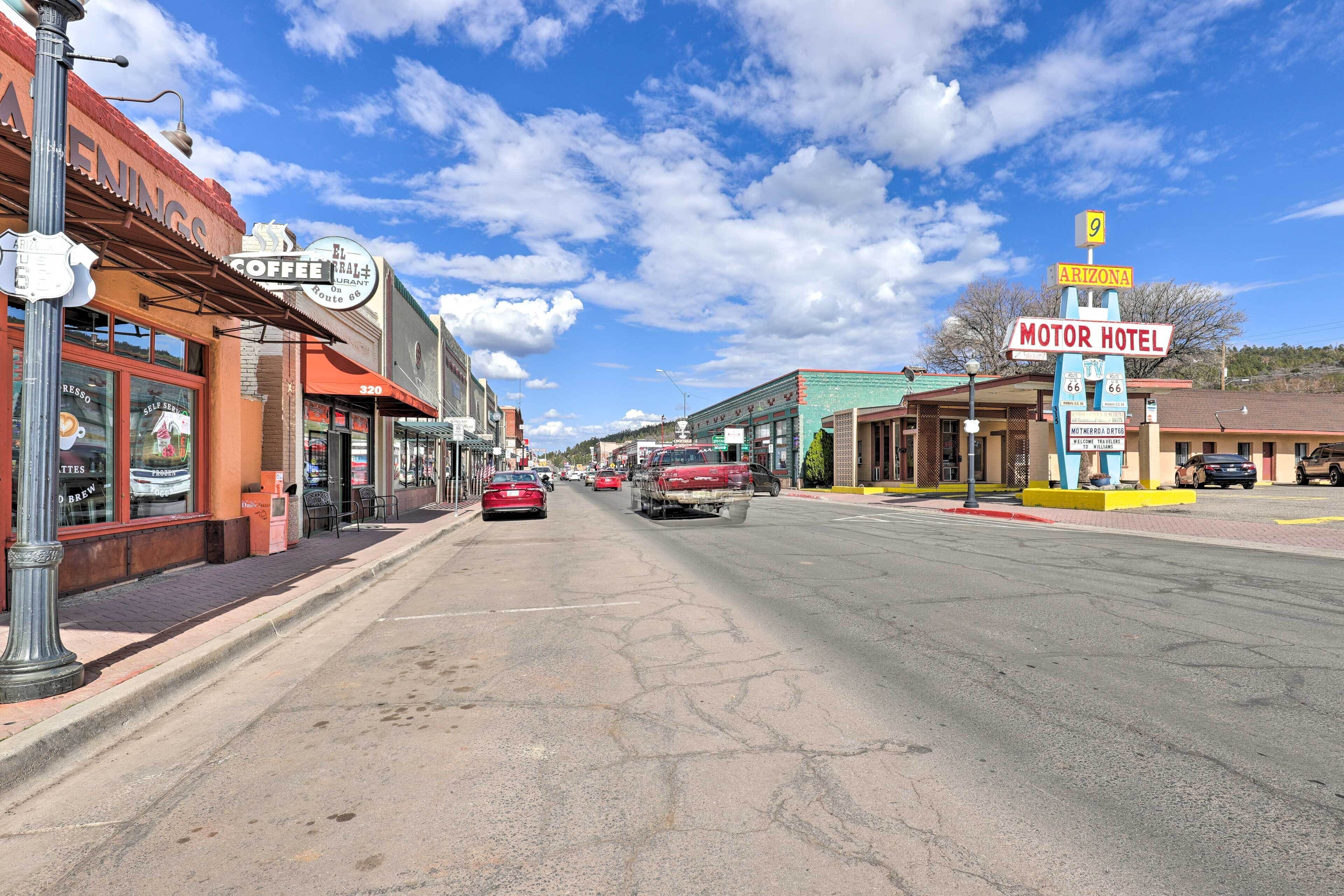 A street lined with various businesses including a motor hotel and a coffee shop.