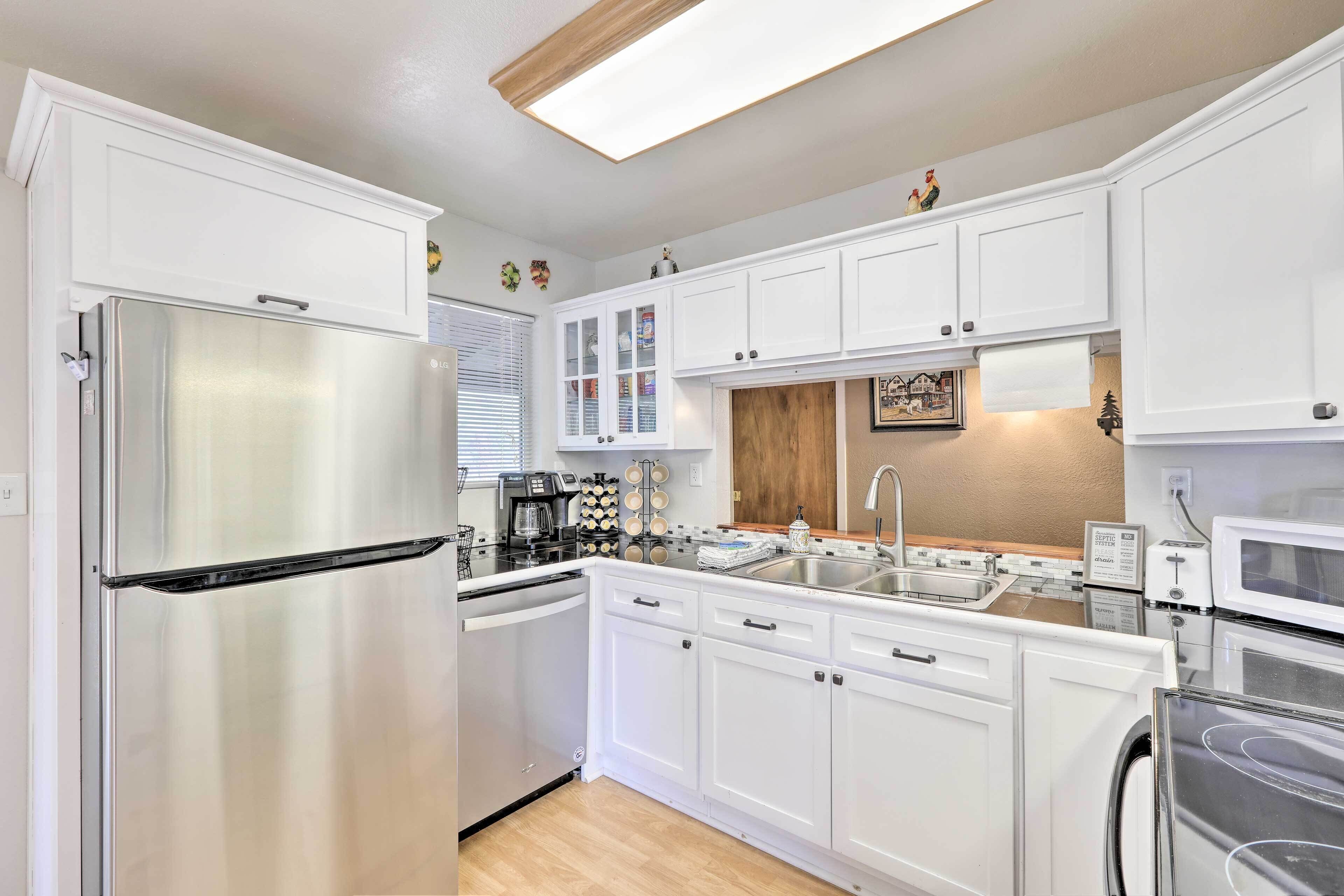 A modern kitchen with white cabinetry, stainless steel appliances, and a wooden backsplash.
