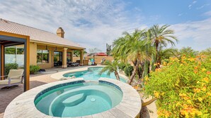 A swimming pool with a hot tub, surrounded by palm trees and cacti, with a covered patio area and outdoor seating. - Putting Green: Golfer's Getaway in Scottsdale (Scottsdale)