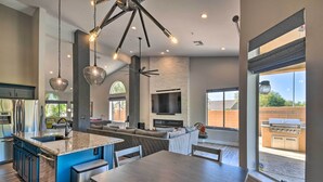 A modern kitchen with a central island, built-in appliances, and a large window overlooking an outdoor grill area. - Putting Green: Golfer's Getaway in Scottsdale (Scottsdale)