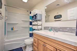 A modern bathroom with a bathtub, toilet, and vanity.