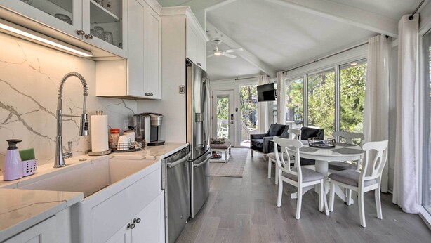 A modern kitchen with white cabinets, a stainless steel refrigerator, and a marble backsplash. - Walk to Harbour Town: Airy Treehouse w/ Bikes (Hilton Head Island)