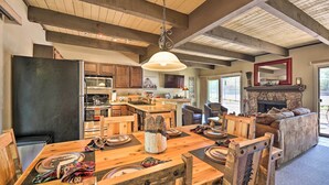 A spacious kitchen with wooden beams, a dining area with a large wooden table, and a cozy living room with a fireplace. - Patio & Fireplace: Country Club Pinetop Condo! (Pinetop)