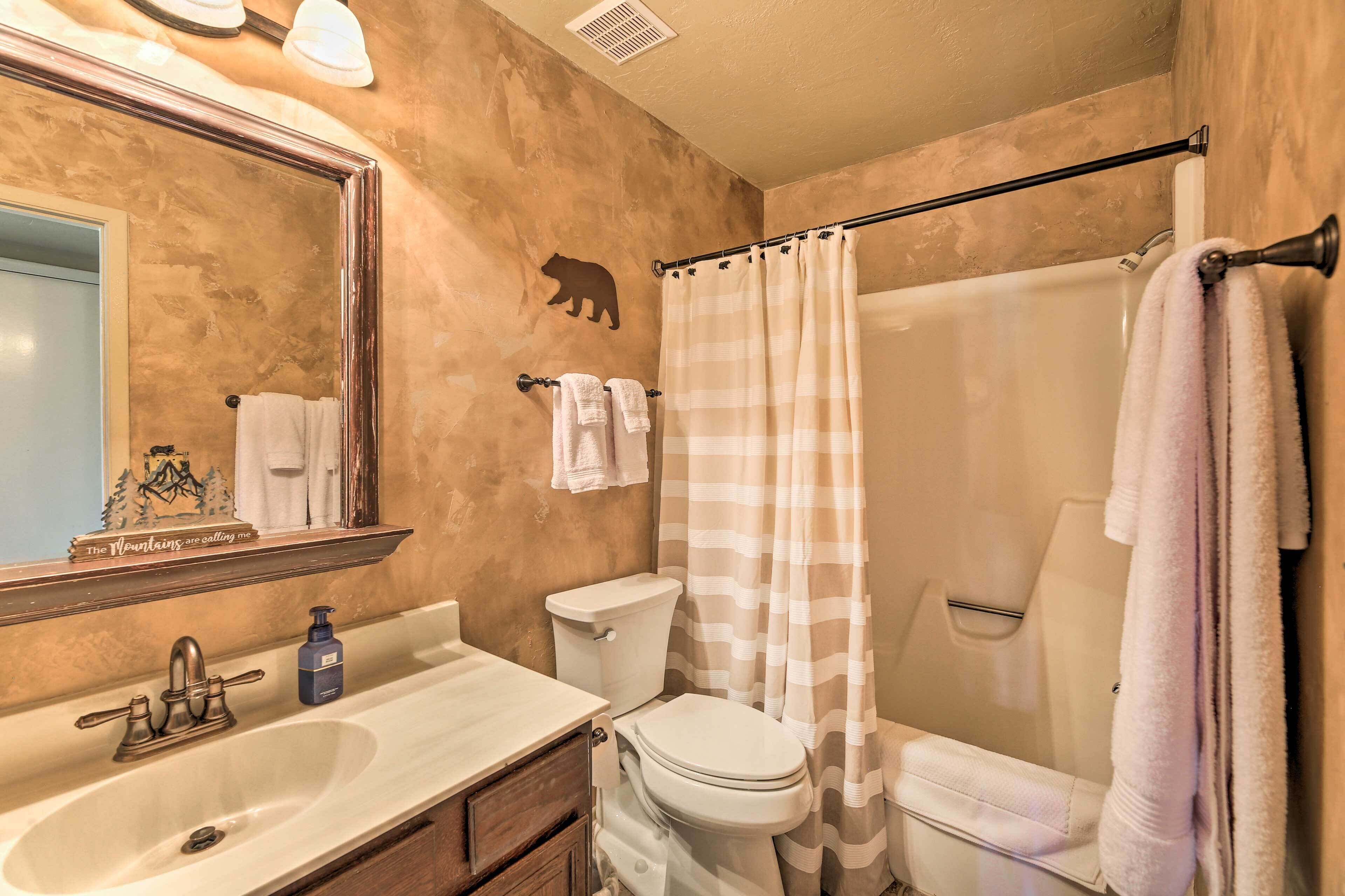 A bathroom with a sink, toilet, and shower curtain.