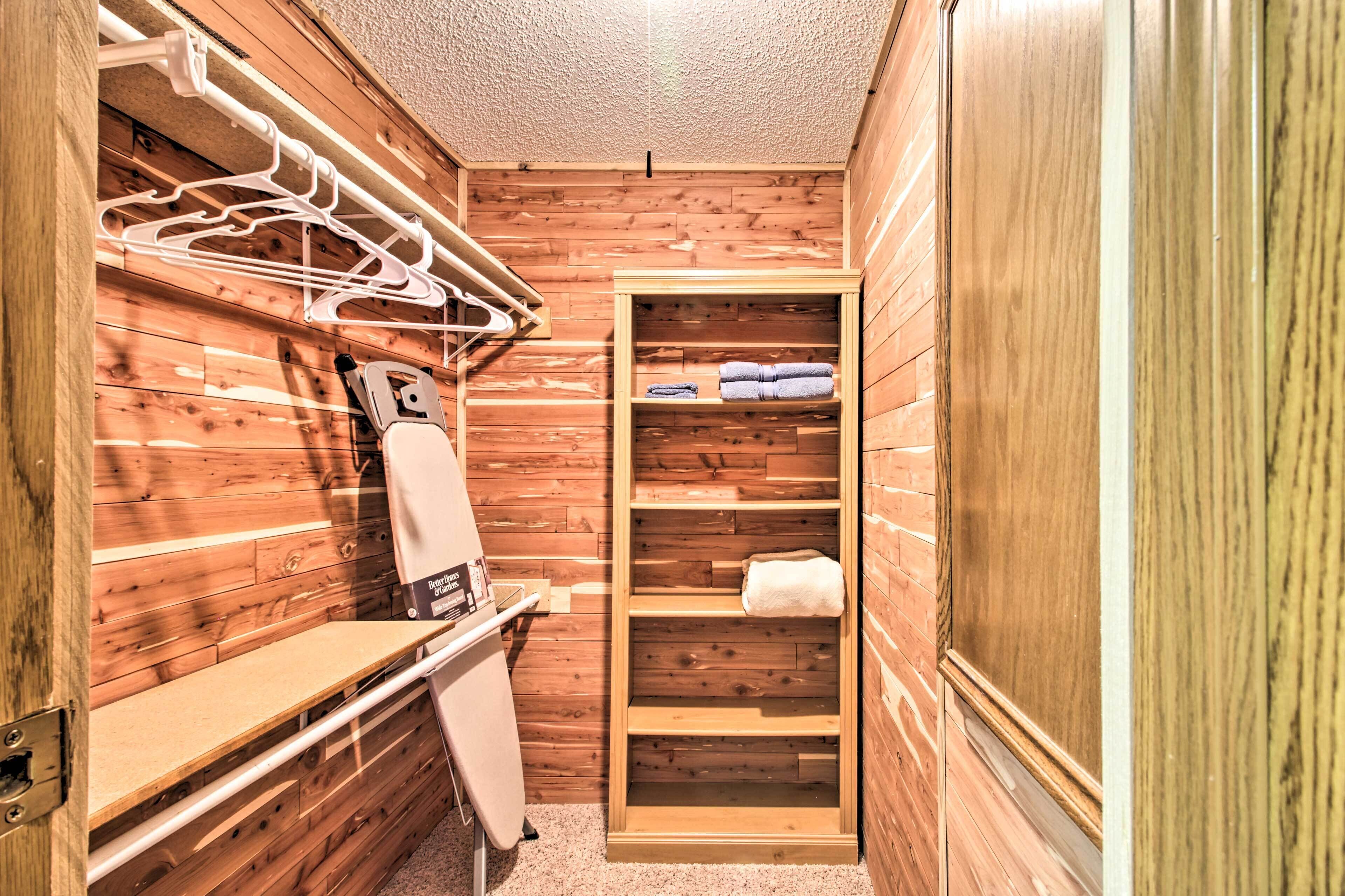 A wooden interior with a towel rack, a bench, and a shelf with towels.