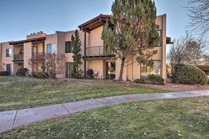 A two-story building with a balcony, a patio, and a well-maintained lawn. - Mtn-view Condo w/ Hot Tub Access in Sedona! (Sedona)