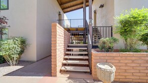 A staircase leading to a second floor, surrounded by a brick wall and potted plants. - Mtn-view Condo w/ Hot Tub Access in Sedona! (Sedona)