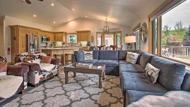 A spacious living area with a large gray sectional sofa, a wooden coffee table, and a patterned rug. - 6 Mi to Big Sky Resort! Group Retreat w/ Mtn Views (Big Sky)